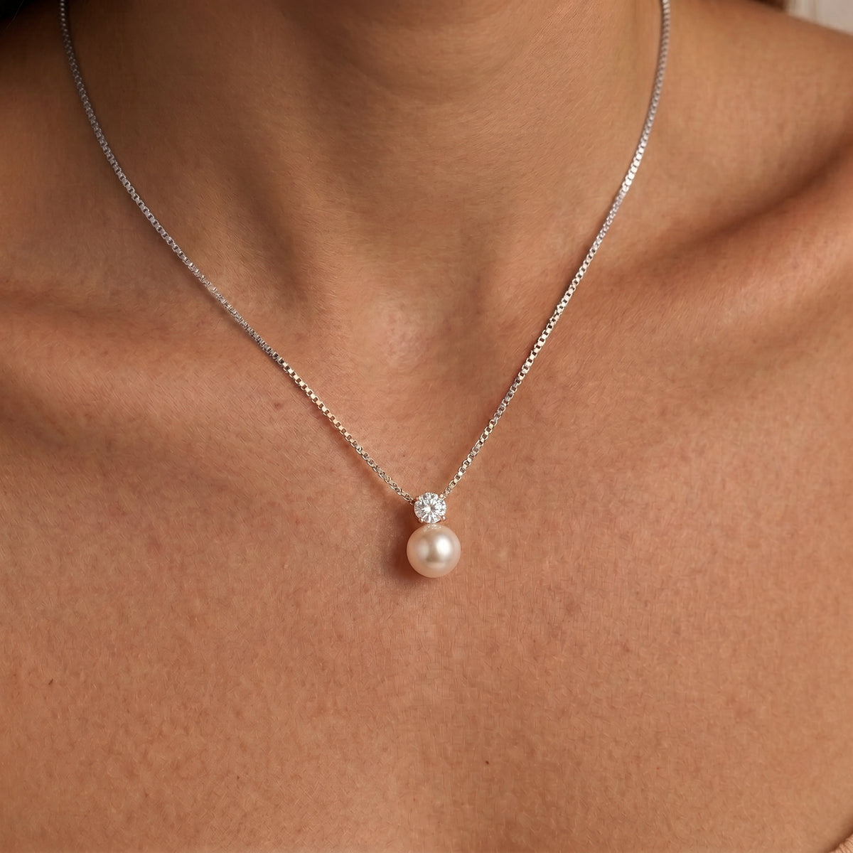 Woman wearing the Arianne silver box chain necklace, a creamy pearl beneath a round crystal