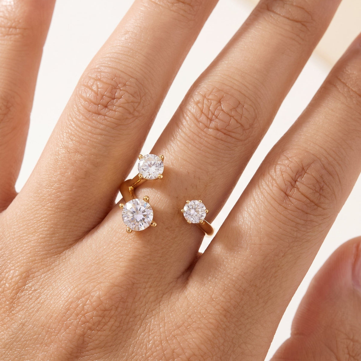 Woman wearing the Adriana three stone gold ring on the hand