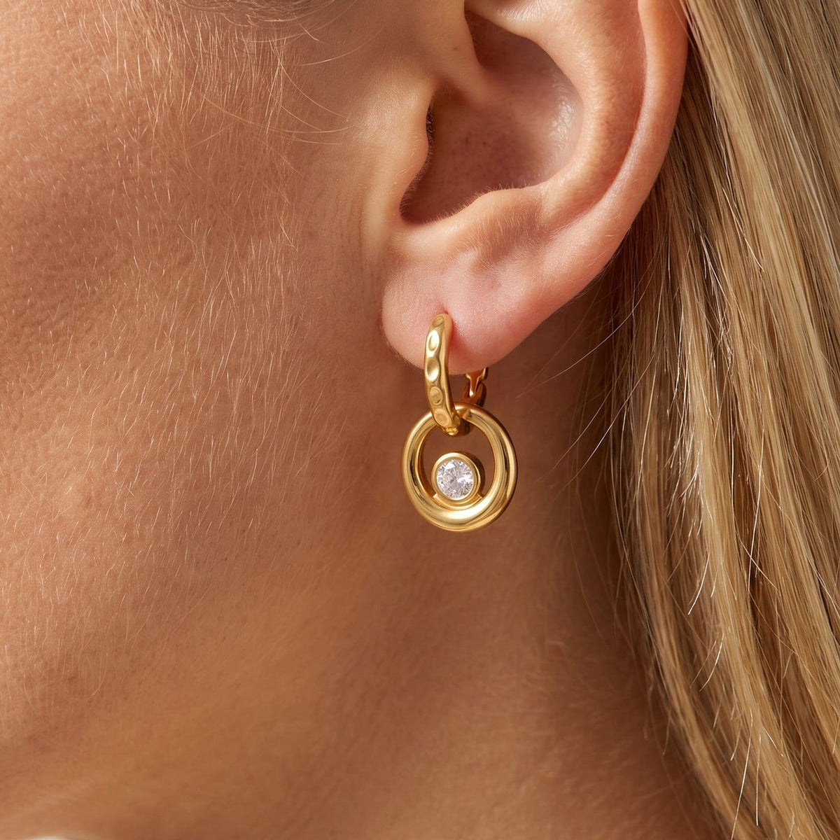 Woman wearing the Amélie circle drop gold earrings on the ear
