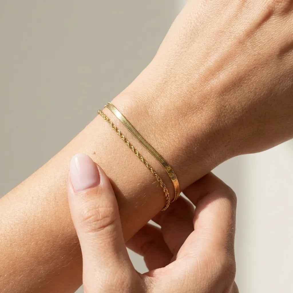 Vida layered gold bracelet with a rope chain and a herringbone chain stacked on the wrist