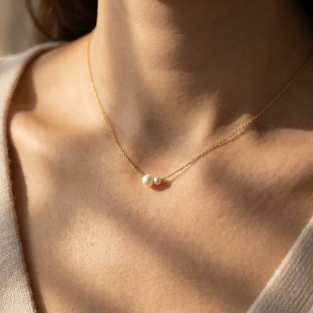 Woman in a cream knit wearing the Sophie twin pearl necklace on a fine gold chain
