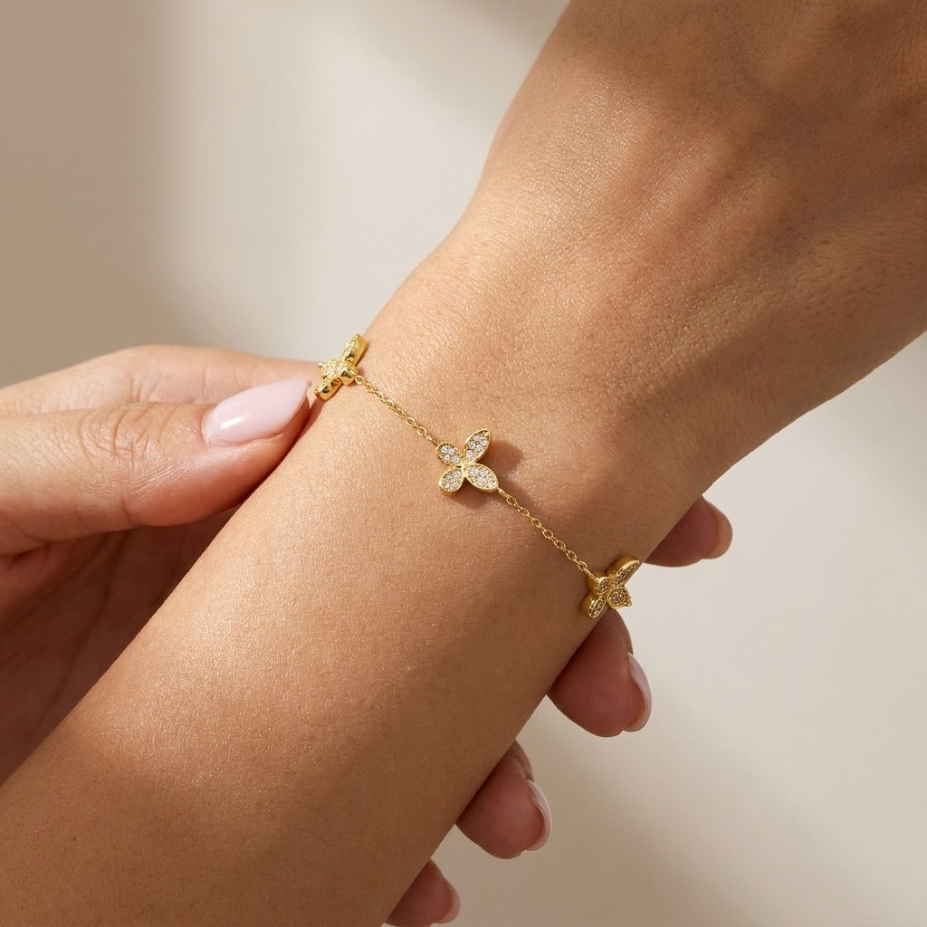 Woman wearing the Élodie Butterfly bracelet in gold with crystal-paved butterfly stations along the chain