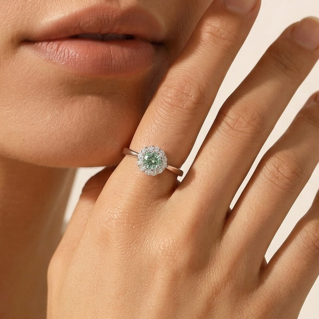 Woman wearing the Ariana crystal silver ring with a green center stone in a clear crystal halo