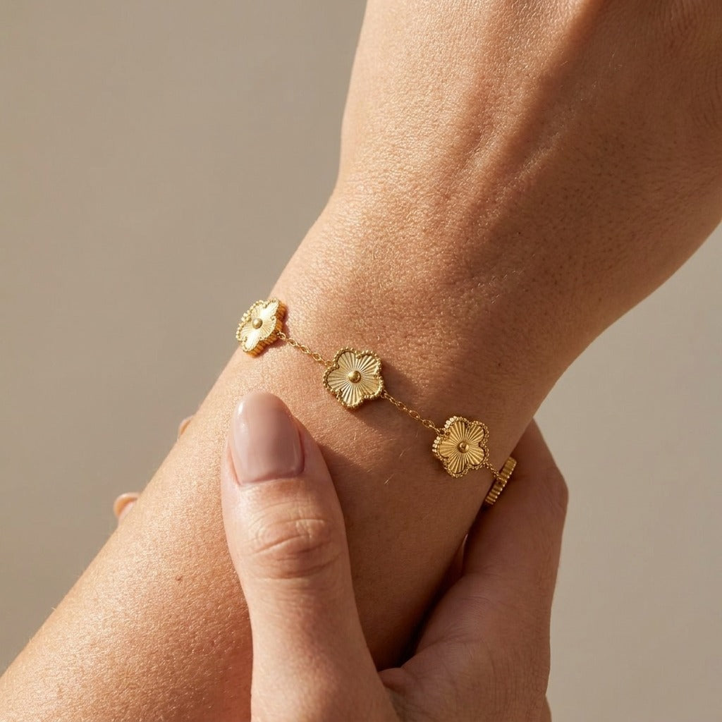 Rowena gold bracelet with ridged clover charms on a fine chain worn on the wrist