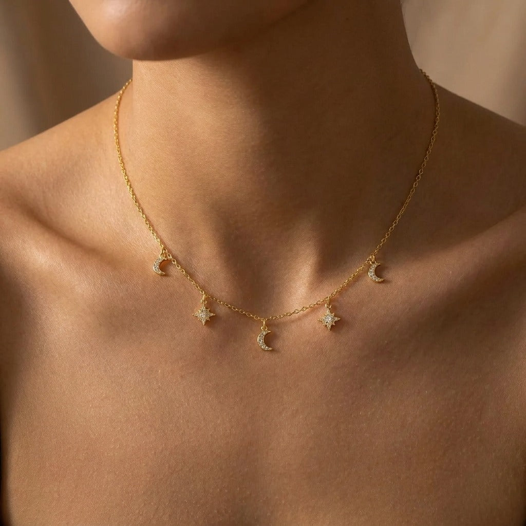 Woman wearing the Amélie moon and star necklace in gold, alternating crescent and star charms