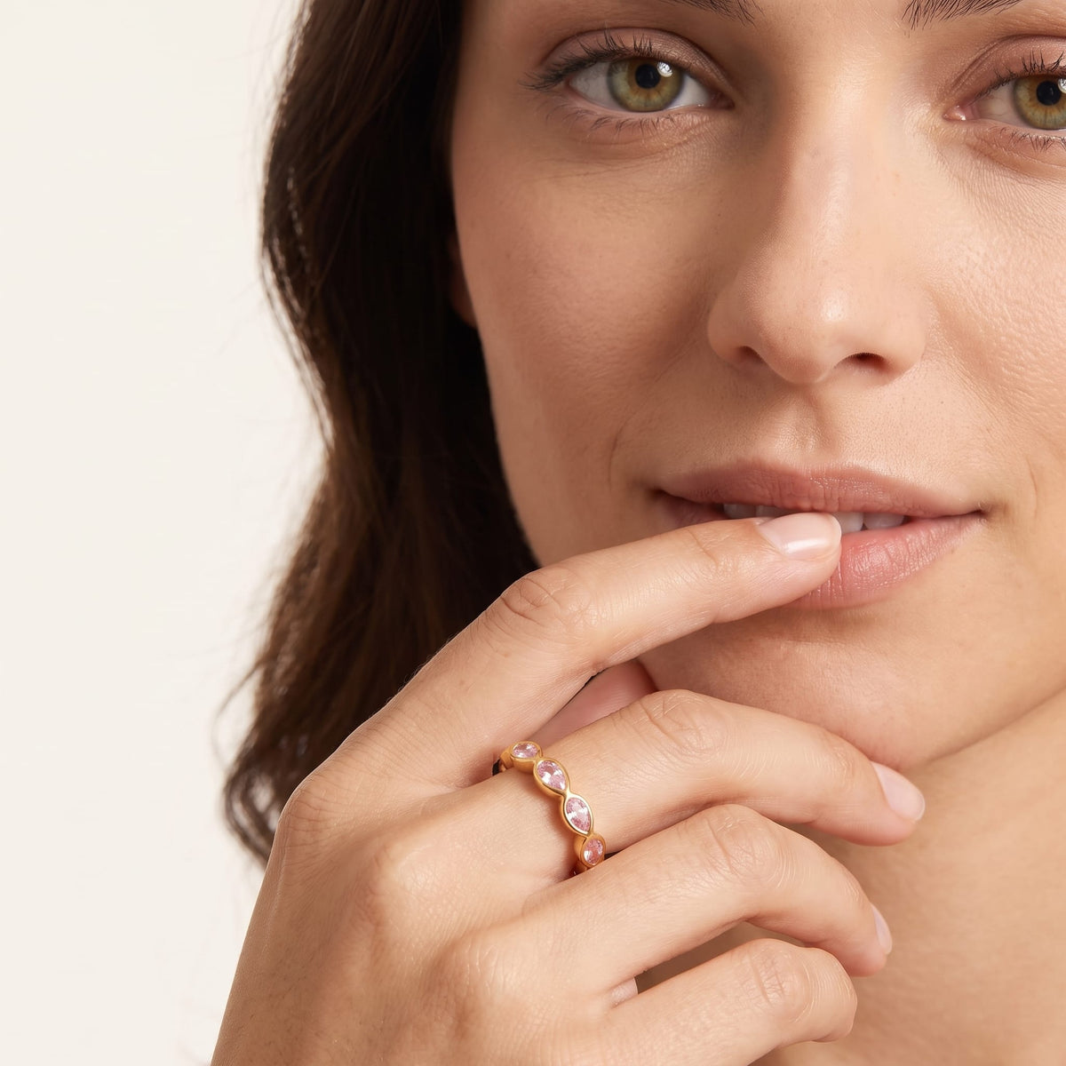 Woman wearing the lodie pink pear gold ring on the hand touching her lip