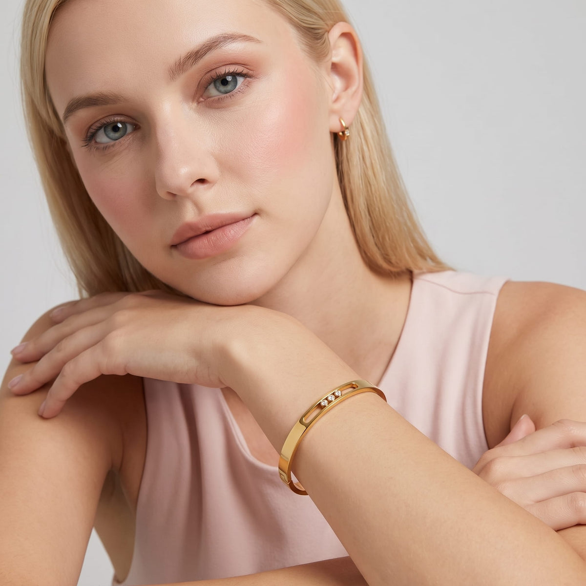 Woman wearing the Elsa sliding crystal gold bangle resting her head on her arms