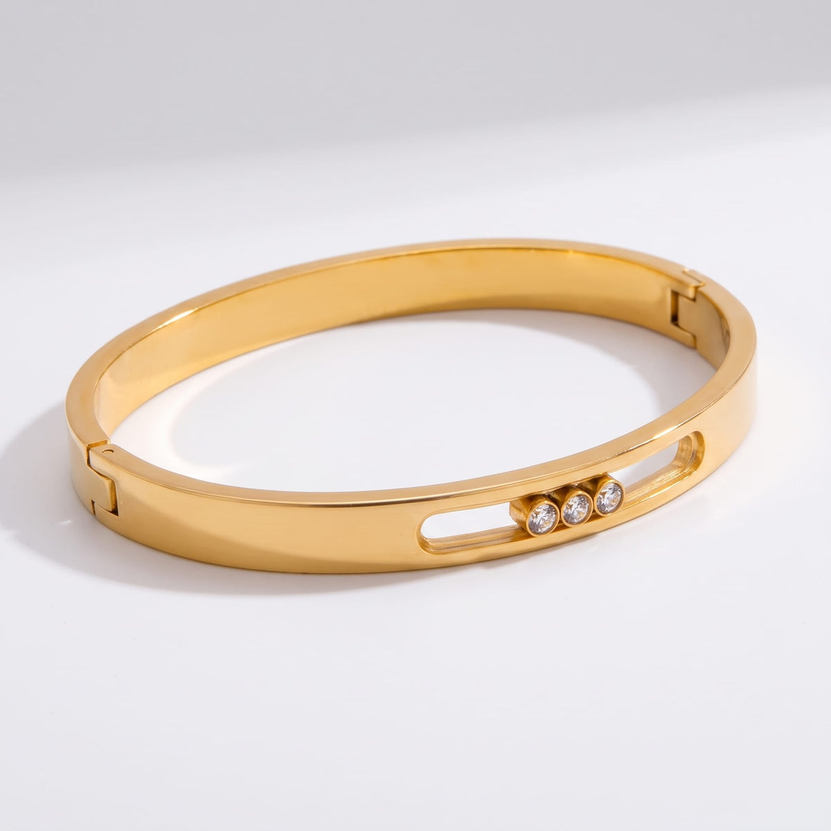 Elsa sliding crystal gold bangle on a plain white surface