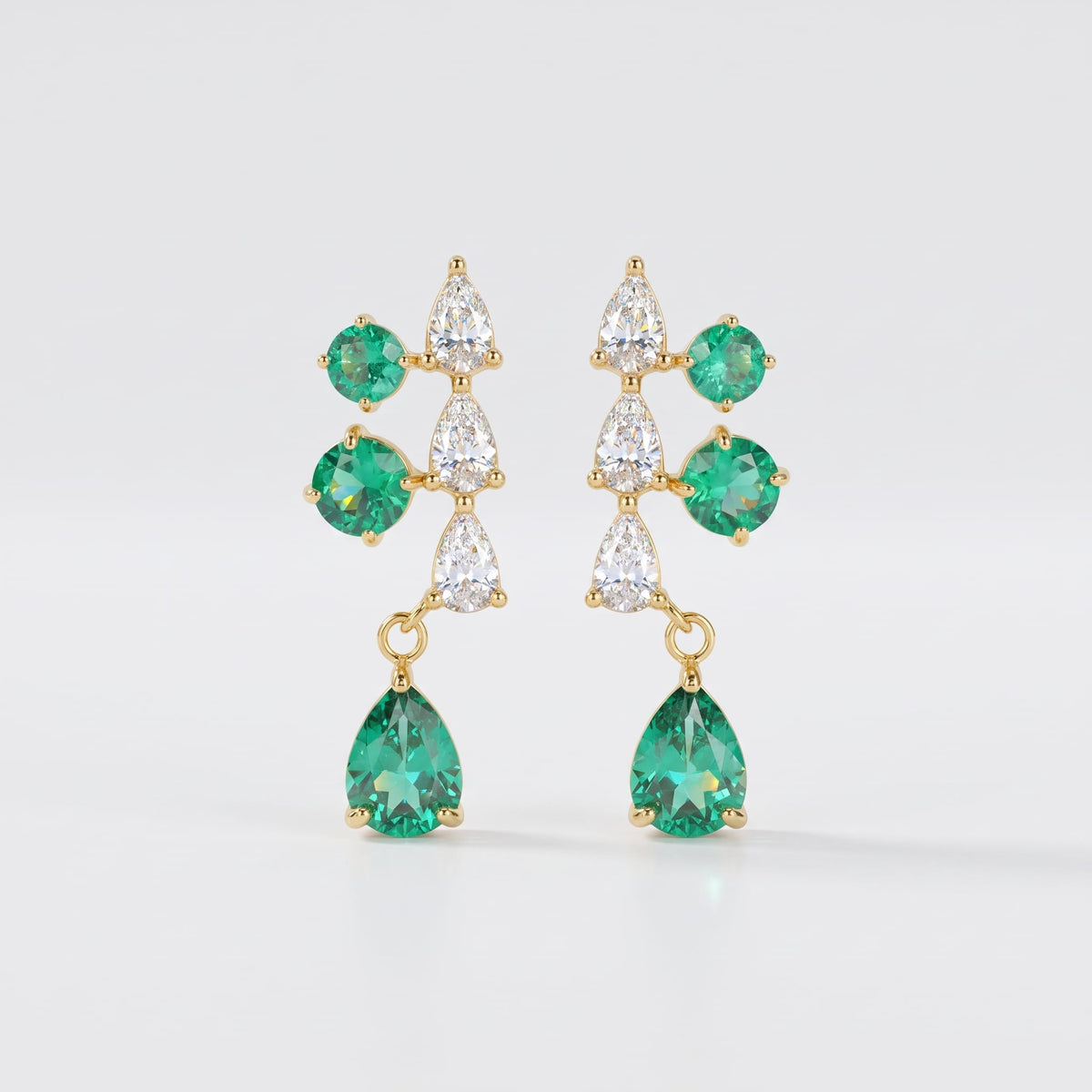 Florentine green cascade gold earrings on a plain white surface showing green and clear stones