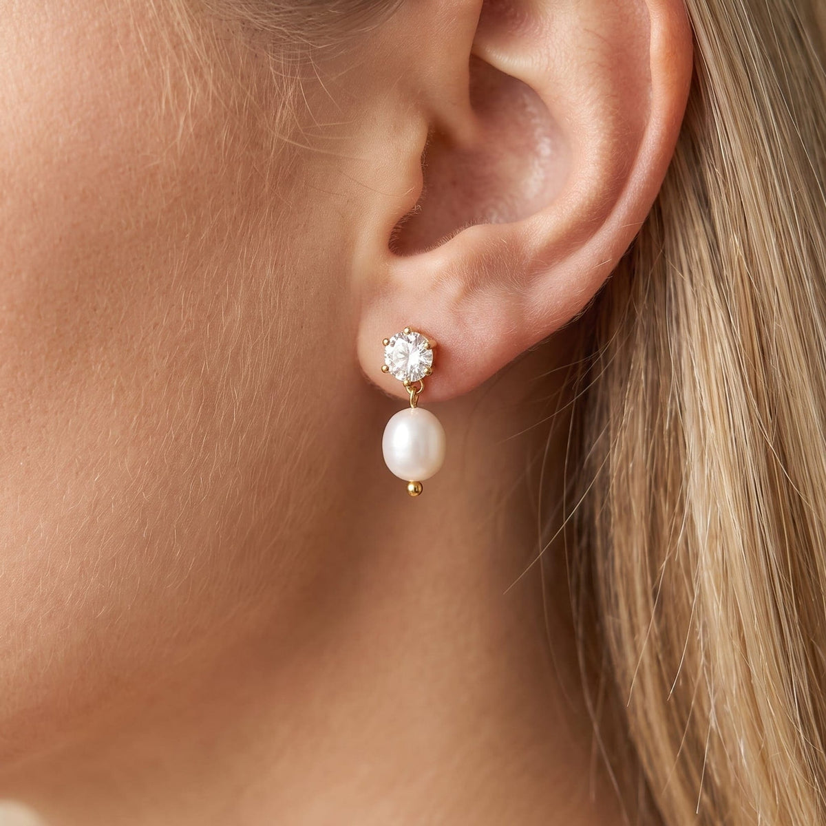 Woman wearing the Ginevra pearl drop gold earrings on the ear