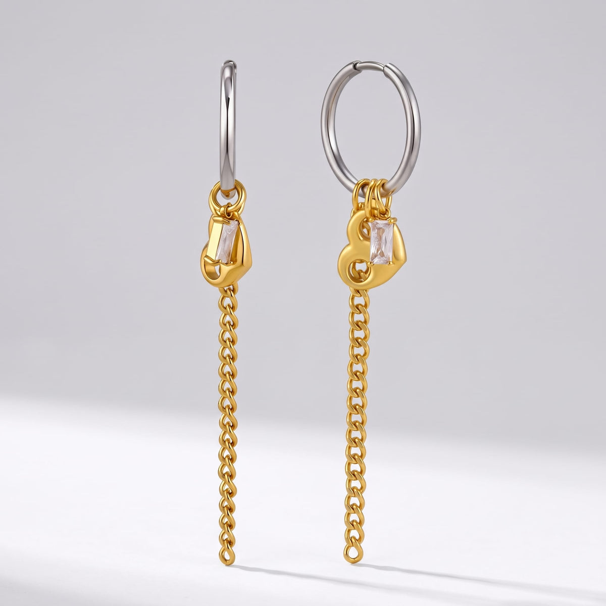 Greta heart chain two-tone earrings on a plain light grey background