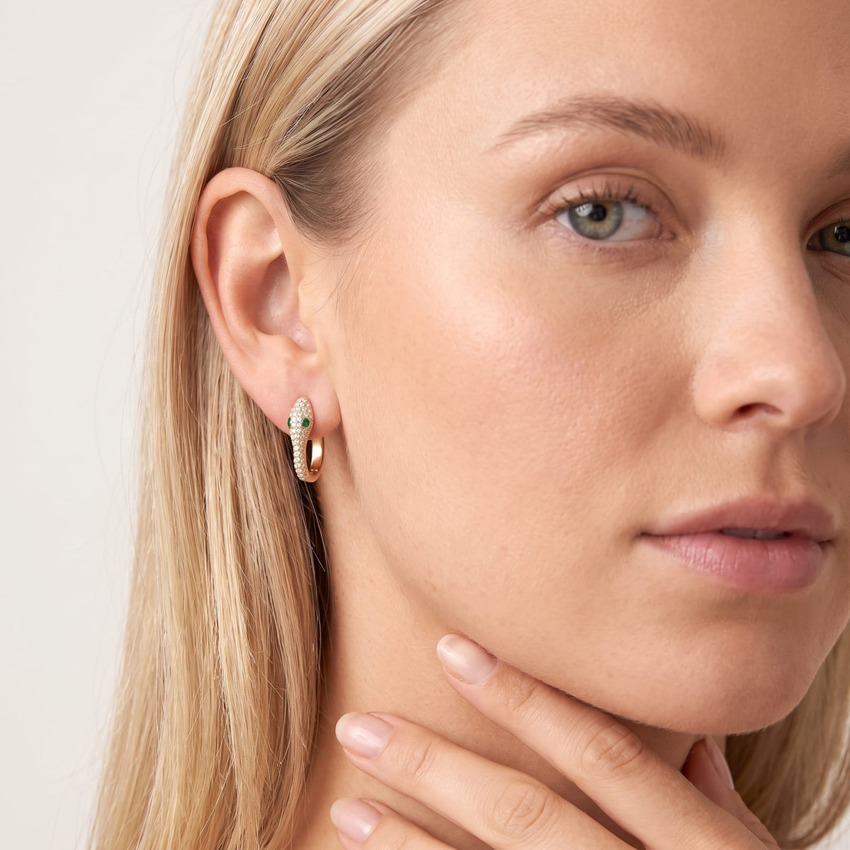 Woman wearing the Sabine pavé snake gold earrings on the ear touching her neck