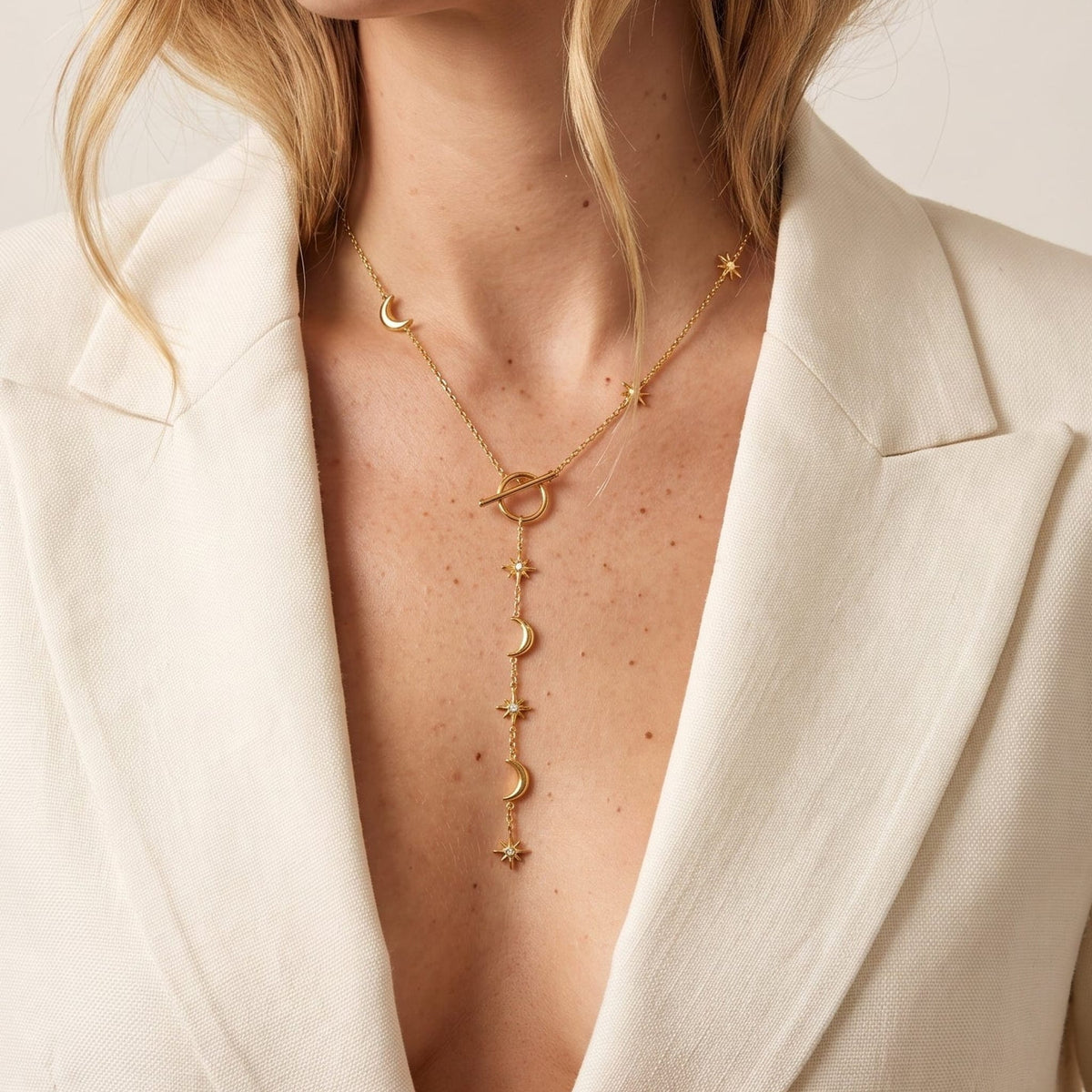 Woman wearing the Thérèse celestial toggle gold necklace at the collarbone