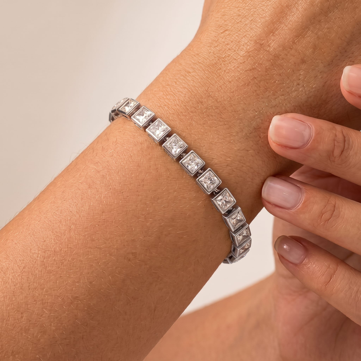 Woman wearing the Valentina princess tennis silver bracelet on the wrist, featuring square crystals