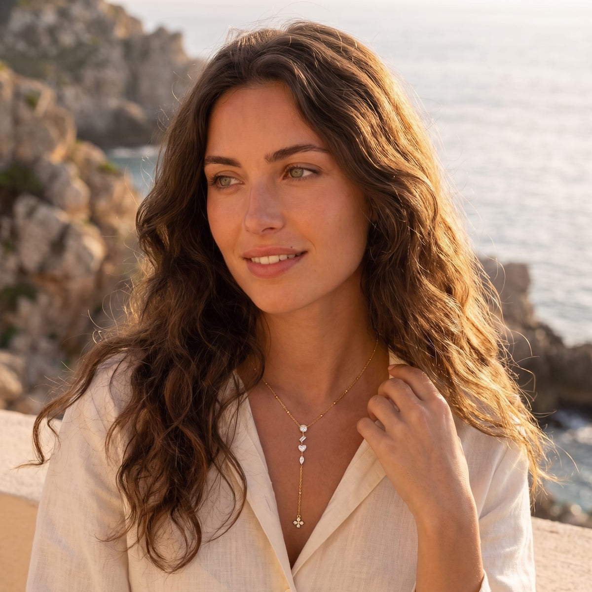 Woman wearing the Victorine mixed cut gold necklace at the throat in a white linen shirt