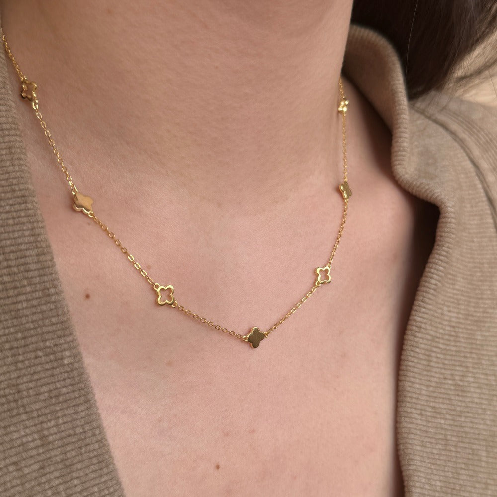 Woman in a taupe knit wearing the Margot gold chain with solid and open clover stations