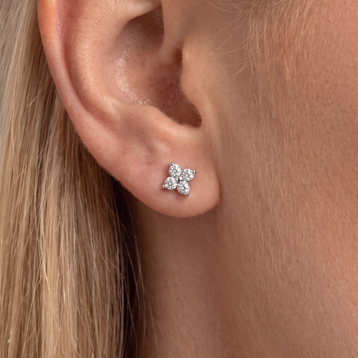 Close view of the Agathe crystal clover stud in silver sitting flat on the earlobe