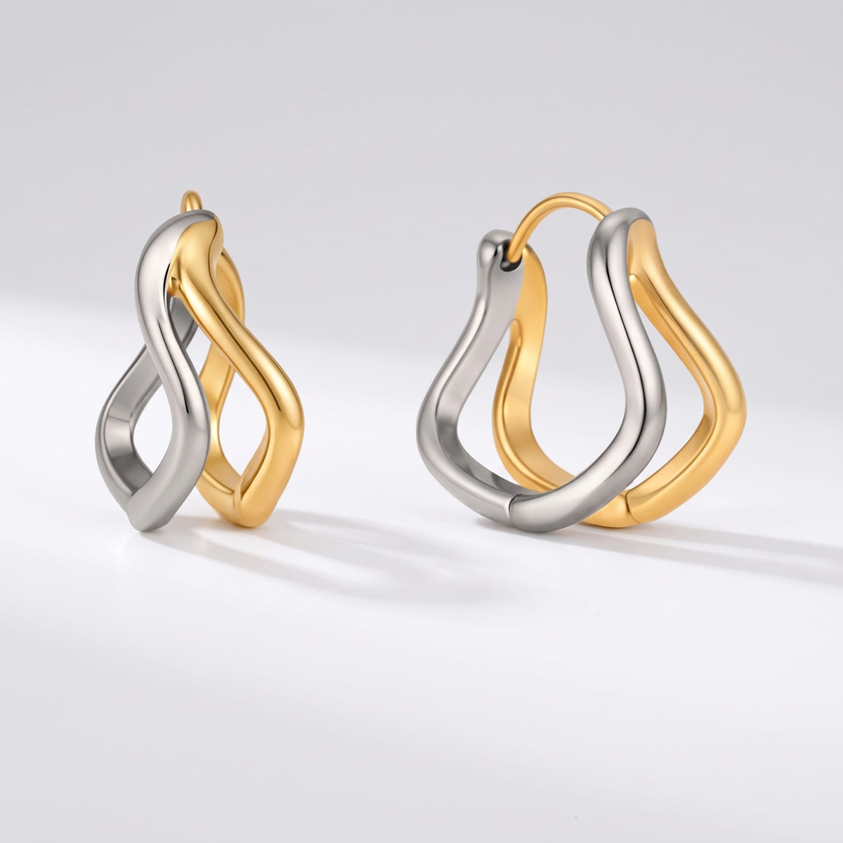 Anouk double wave two-tone earrings on a plain light gray background