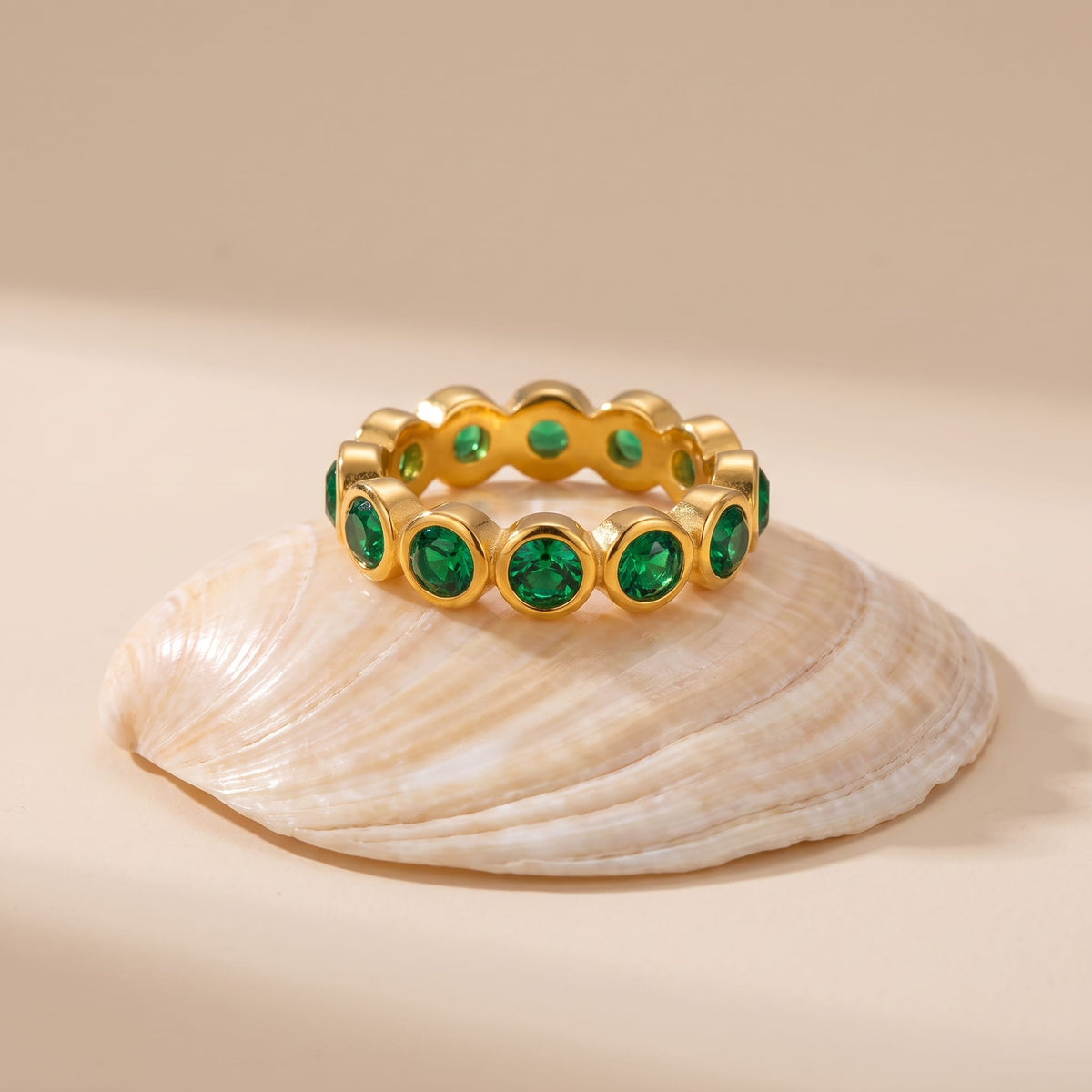 Ariana green round gold ring on a seashells top