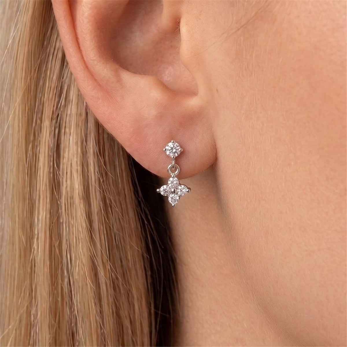 Blonde woman wearing the Astrid silver earring, a crystal stud with a four-stone clover drop