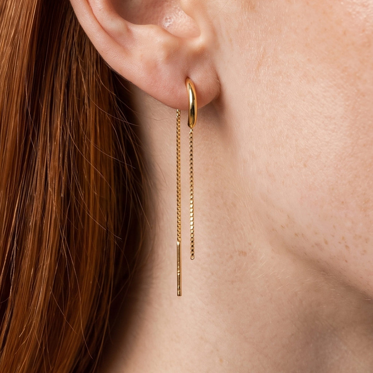 Close view of a red-haired woman wearing the Camille gold threader with two fine box chains