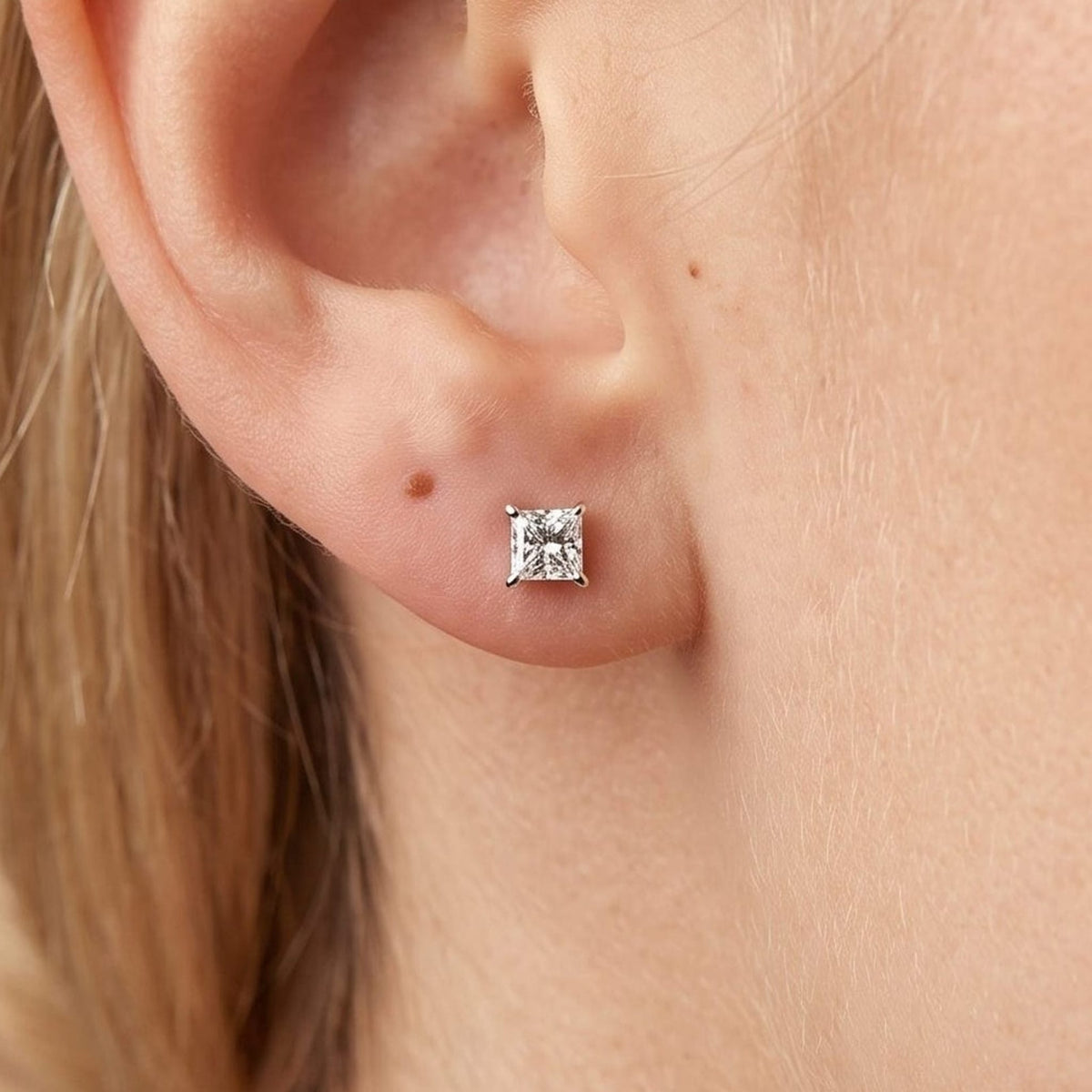 Earlobe with the Chloe square crystal stud in a four-prong gold setting