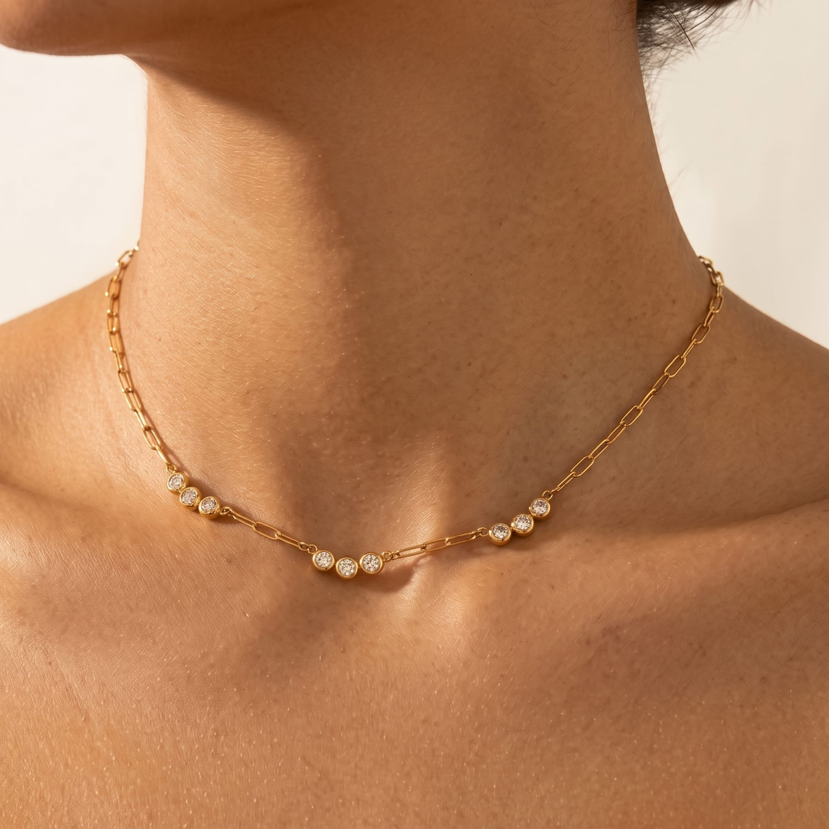 Woman wearing the Clara crystal trio gold necklace at the collarbone