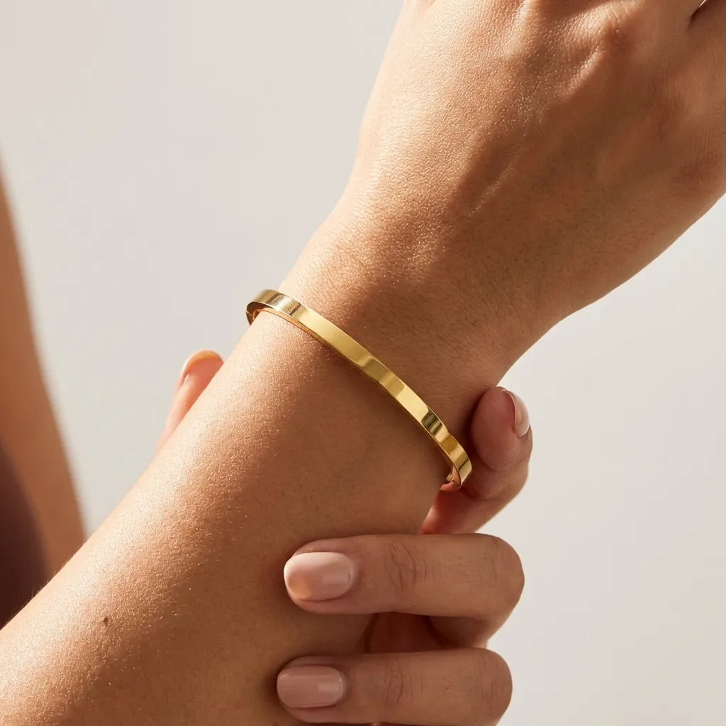 Sarah plain polished gold bangle worn on the wrist