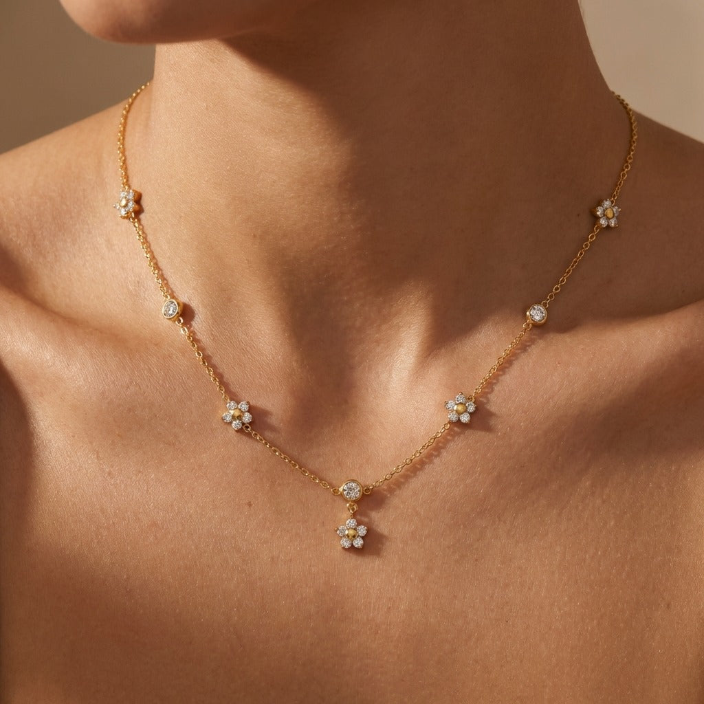 Woman wearing the Mia flower crystal necklace in gold, crystal daisies with a center flower drop