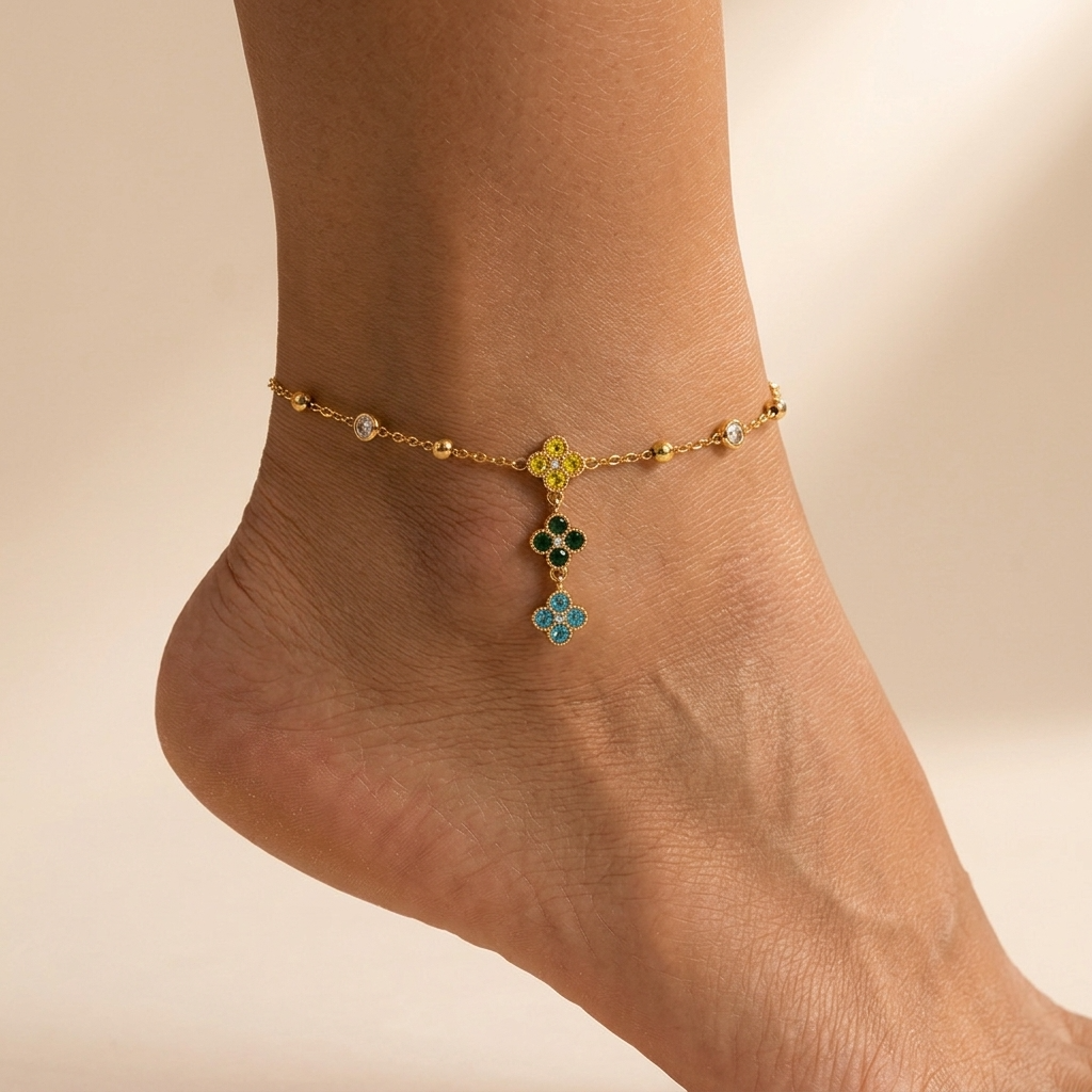 Giulia clover anklet with a yellow, green and blue crystal clover drop on a beaded gold chain
