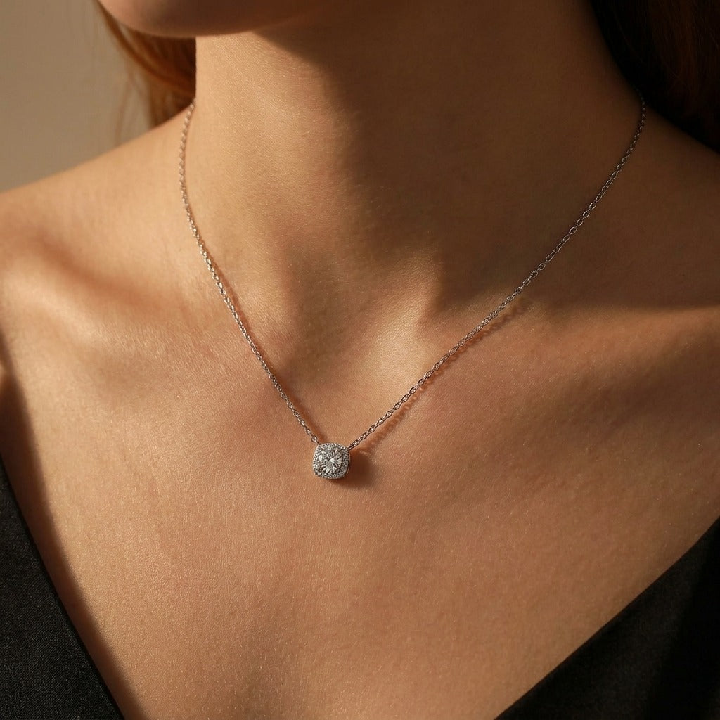 Woman wearing the Olivia Escouade silver necklace with a square crystal halo pendant