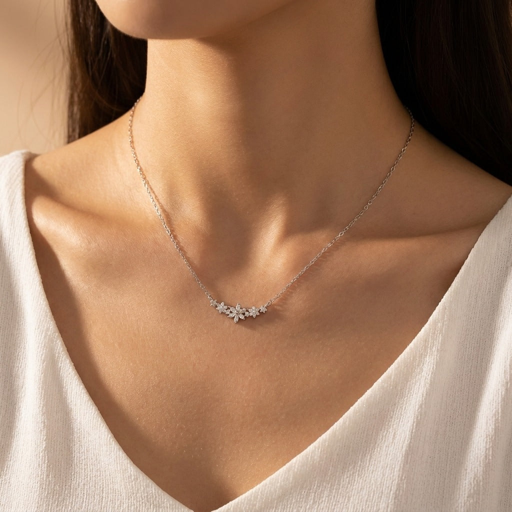 Woman wearing the Camille silver necklace with a cluster of crystal flowers at the center