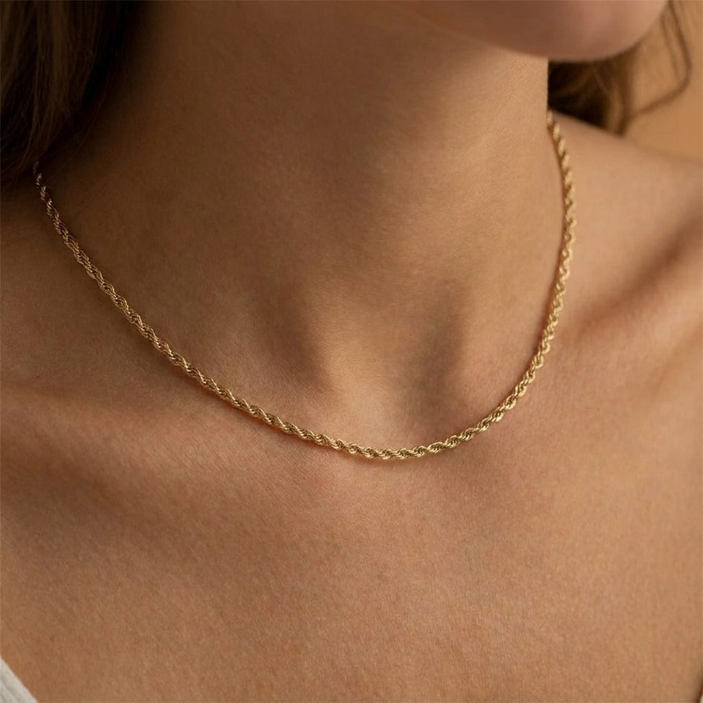 Woman wearing the Antonela twisted rope chain necklace in gold at the base of the neck