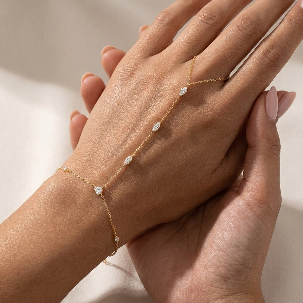 Woman wearing the Amélie gold hand chain with marquise crystals from wrist to finger loop