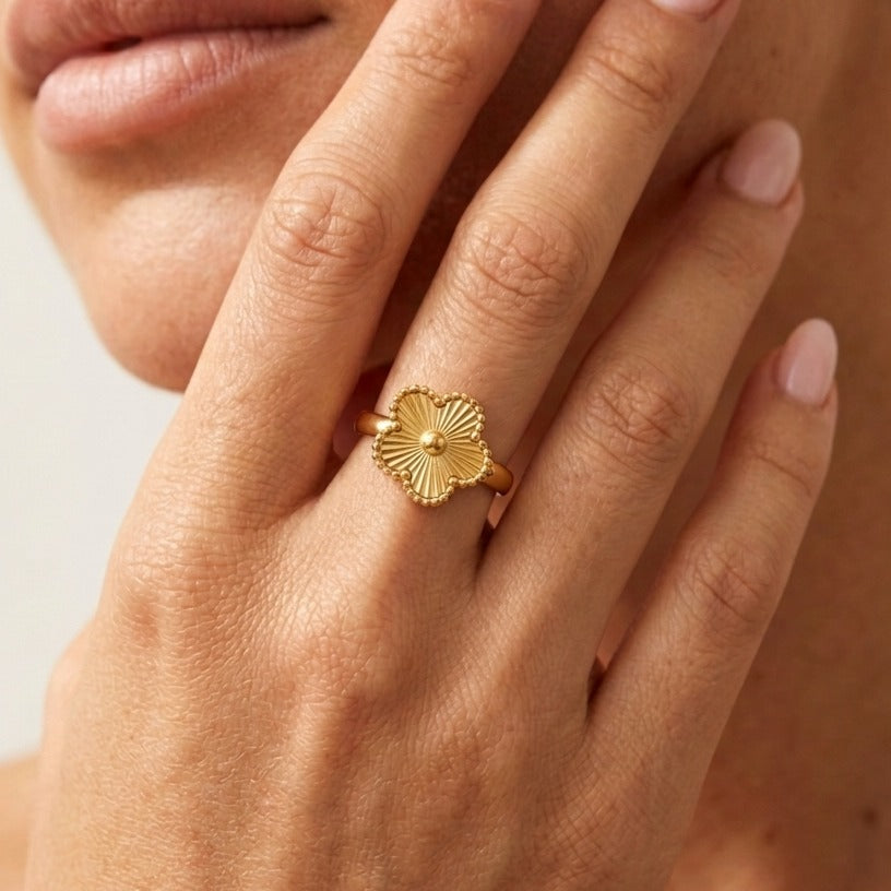 Woman wearing the Rowena gold flower ring, four ridged petals edged with tiny beads