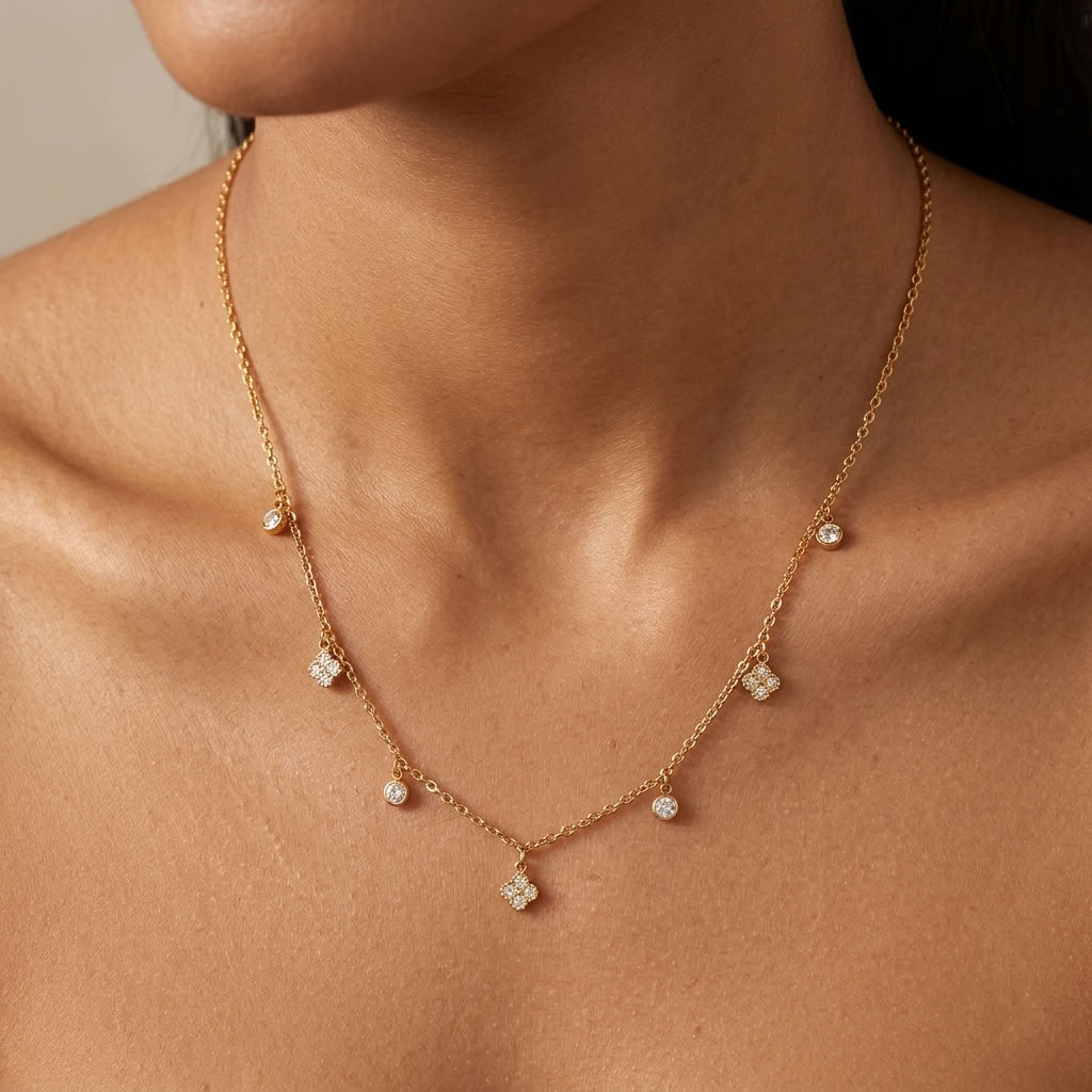 Woman wearing the Sienna gold necklace, crystal clover charms spaced along a fine chain