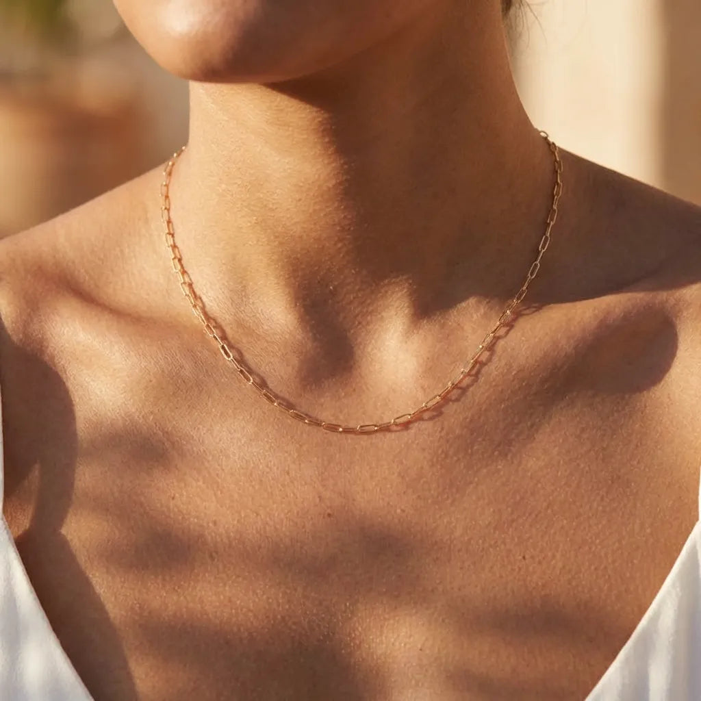 Woman wearing the Nadia gold paperclip chain necklace, long open links at the collarbone