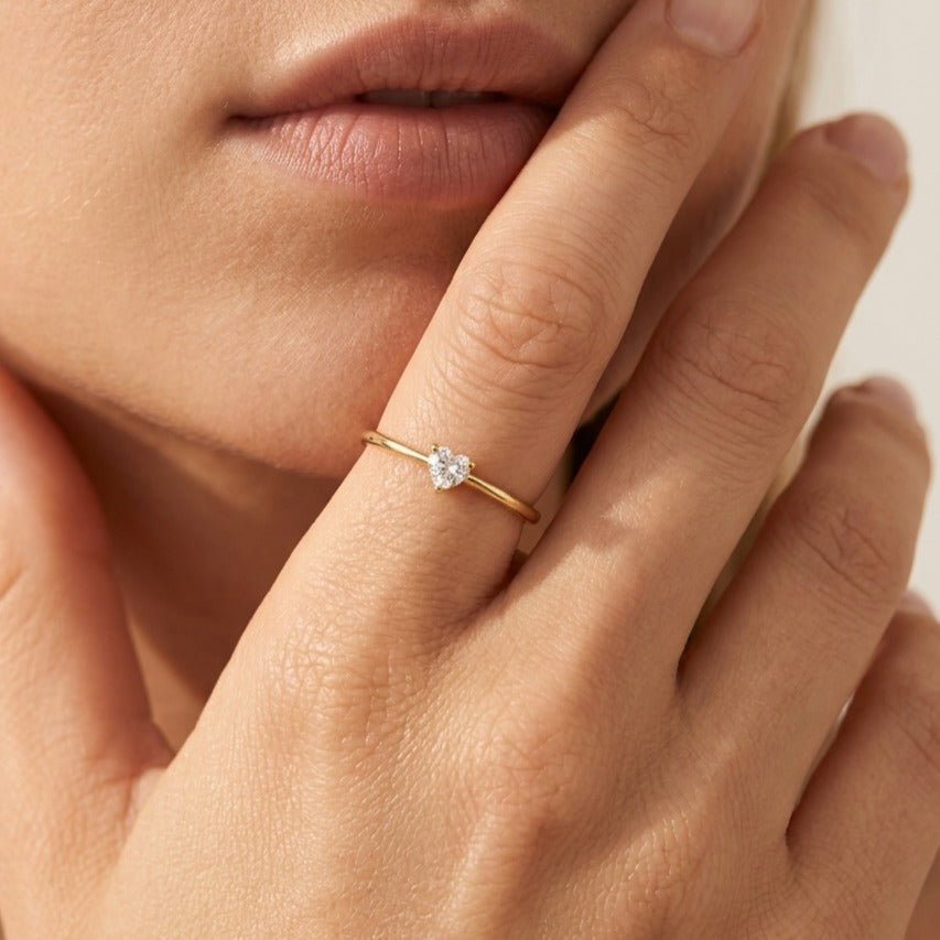 Woman wearing the Léa crystal heart ring in gold, a heart-shaped crystal on a thin band