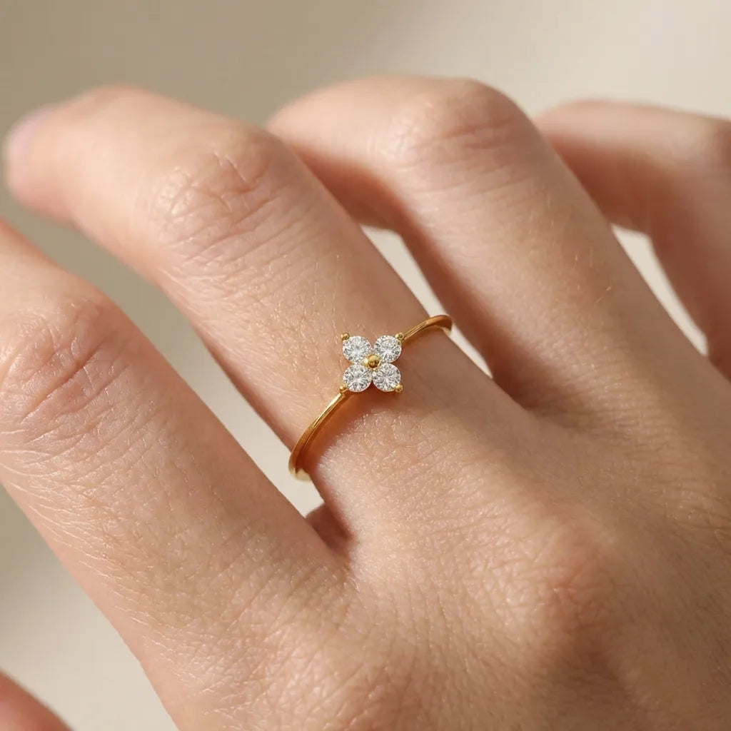 Hand wearing the Mia gold ring with a four-stone crystal clover on a slim band