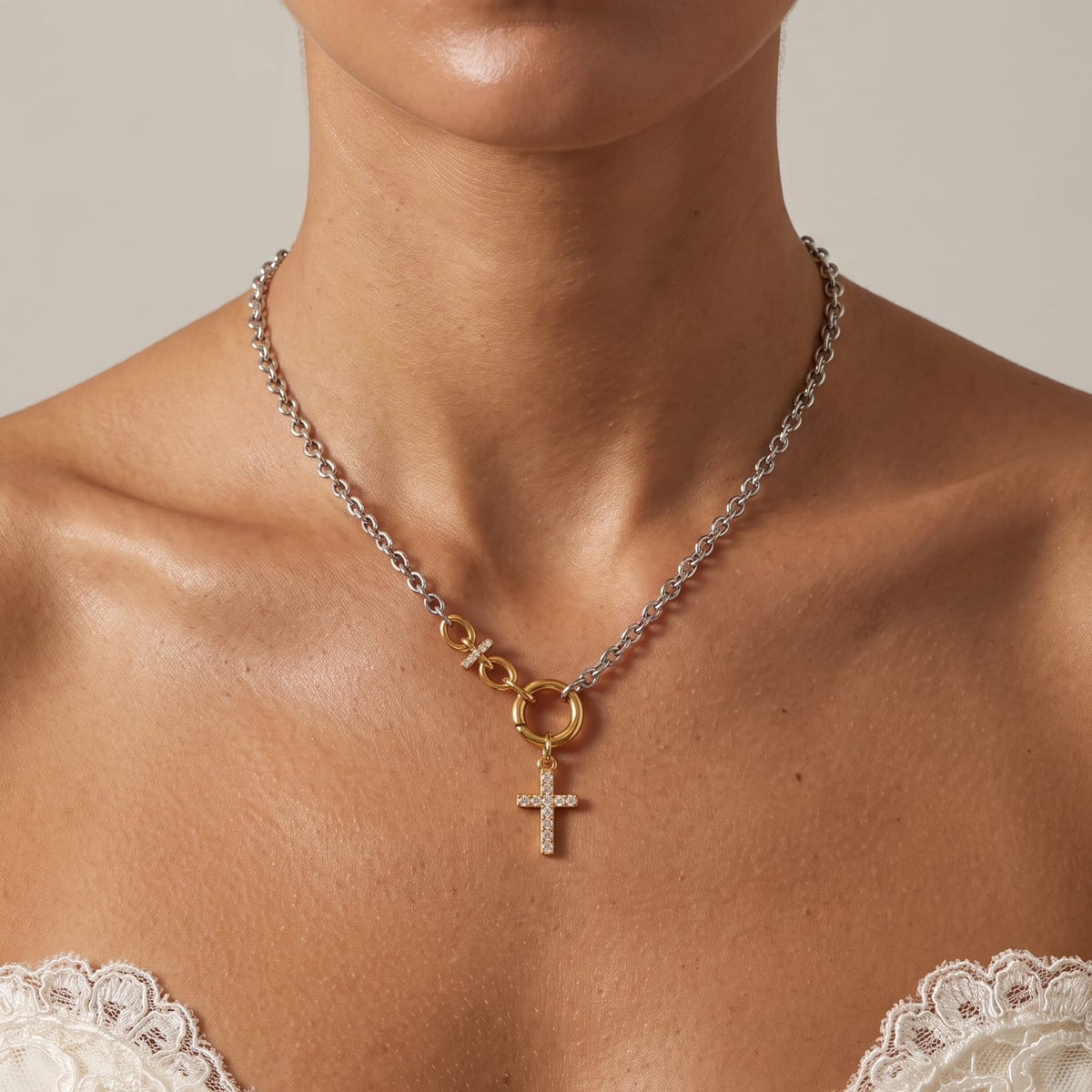 Woman wearing the Eugénie cross charm two-tone necklace at the collarbone in a lace white dress