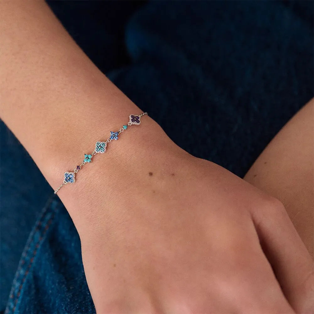 Bracelet with blue gemstones on a wrist against a dark background