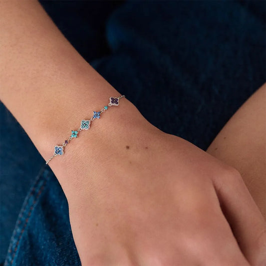 Bracelet with blue gemstones on a wrist against a dark background