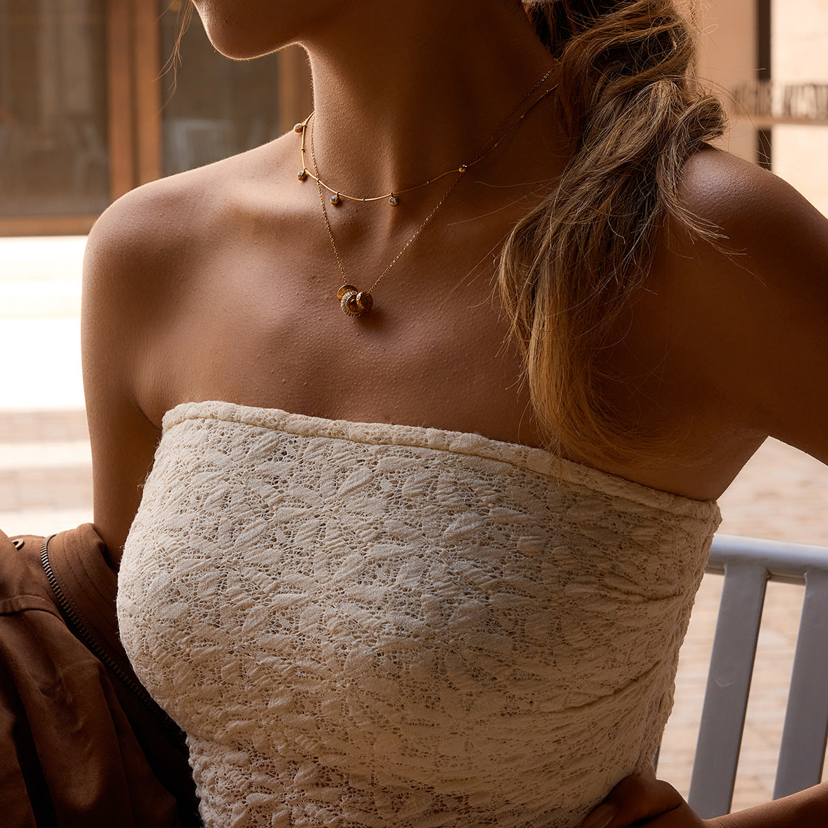 Fiona rondelle charm necklace worn under a beaded satellite choker with a lace bandeau top