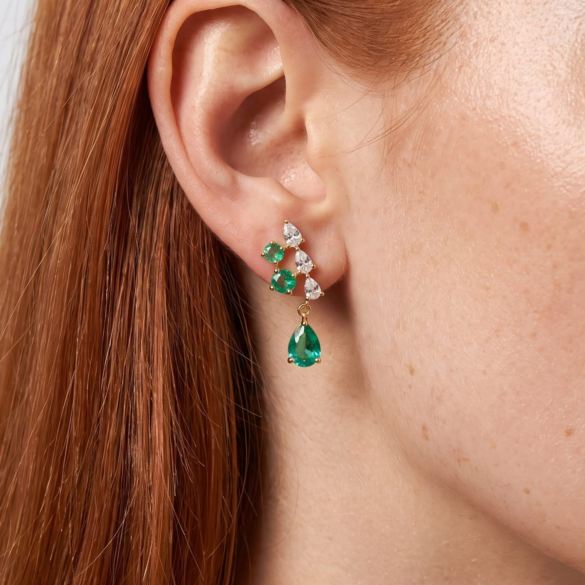 Woman wearing the Florentine green cascade gold earrings on her ear close up with red hair
