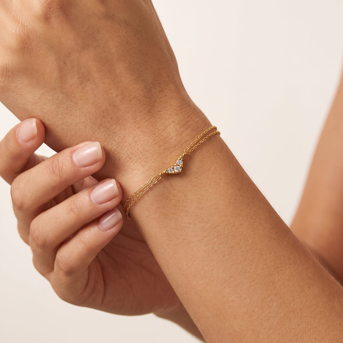 Wider view of a woman wearing the Inès crystal chevron gold bracelet on the wrist