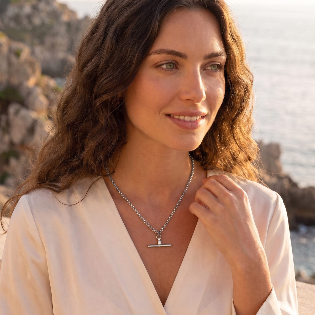 Woman wearing the Joséphine t-bar crystal silver necklace at the collarbone in a white blouse