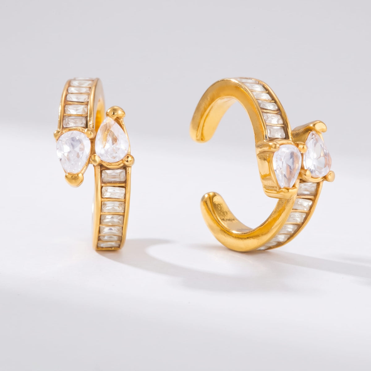 Laure baguette gold ear cuffs on a plain white surface with soft shadows