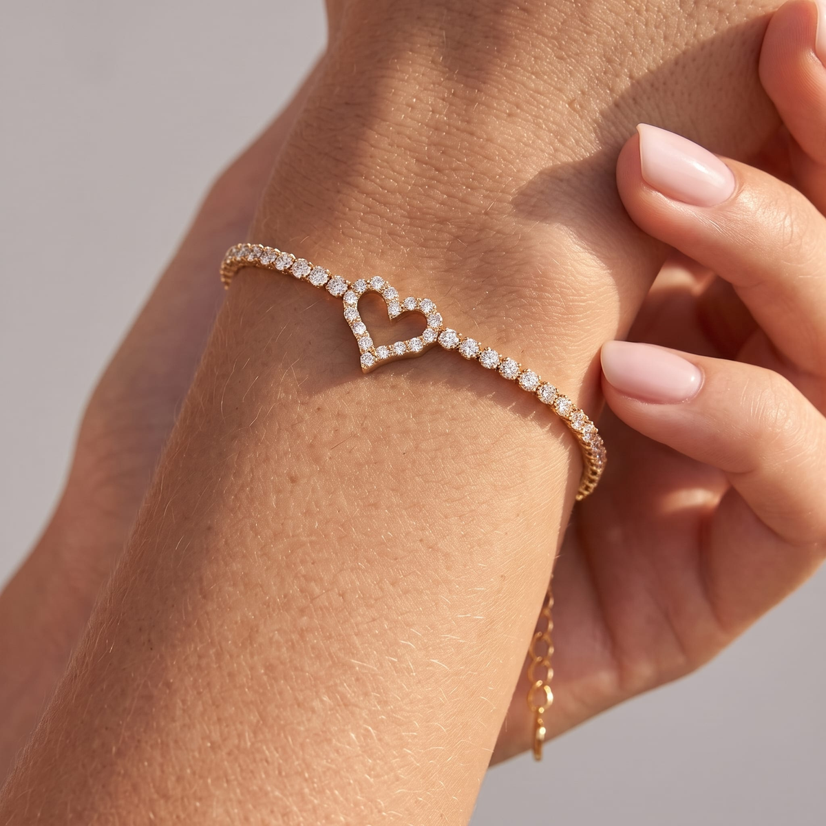 Woman wearing the Lucienne gold tennis bracelet with an open crystal heart at the center