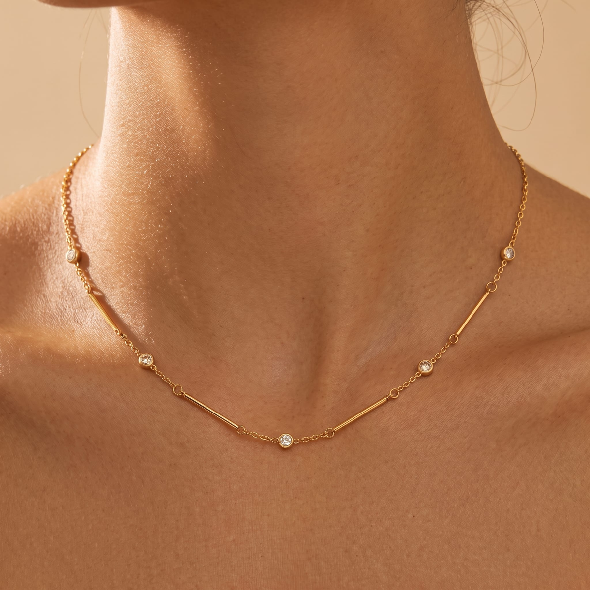 Woman wearing the Lydia crystal station gold necklace at the collarbone, with small round crystals