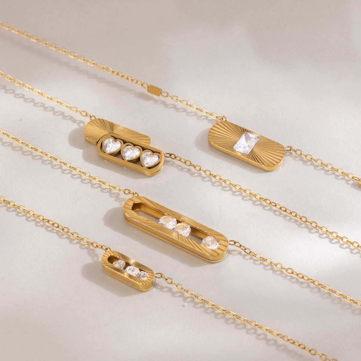 Margaux fluted oval frames with loose round crystals among sunburst pendants on satin